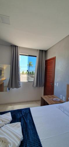 a hotel room with two beds and a window at Hotel Da Orla in Aracaju