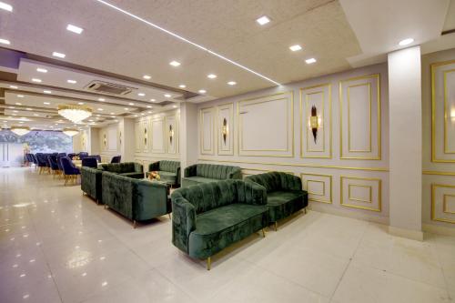 a waiting room with green couches and tables and chairs at Southwest Inn - Boutique Hotel in New Delhi