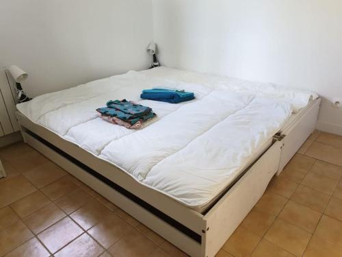 - un grand lit avec deux sacs au-dessus dans l'établissement Escapade bucolique vallée de la Loire, à Maillé