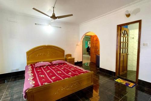 a bedroom with a bed with a red blanket at Kumar Para Deluxe Villa in Sylhet