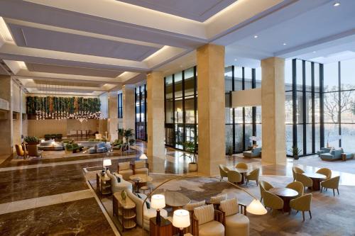 a lobby of a hotel with tables and chairs at The Westin Los Angeles Airport in Los Angeles