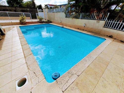 basen z błękitną wodą na dziedzińcu w obiekcie Le Nil Appartement Cosy tout confort w mieście Baie-Mahault