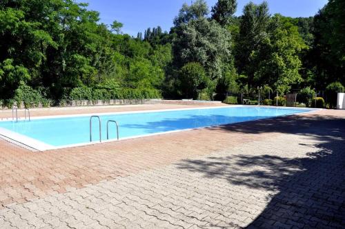 a large swimming pool with a brick walkway around it at Chalet 6 places in Saint-Thomas-en-Royans