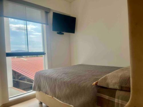 1 dormitorio con cama y ventana grande en Moderno departamento Vallecito, en Arequipa