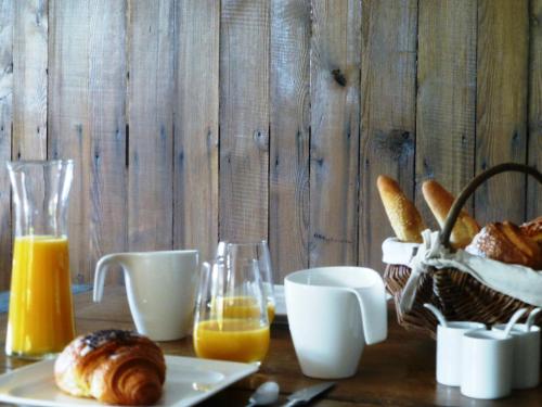 a table with a plate of bread and orange juice at L’Été en Novembre in Kirrwiller