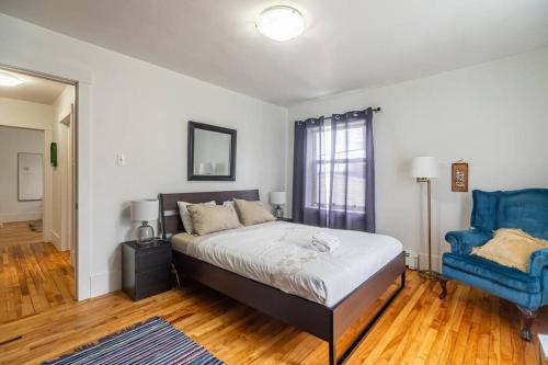 een slaapkamer met een bed en een blauwe stoel bij Large & Sunny Beautiful Home #103 in Halifax