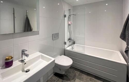 a white bathroom with a toilet and a tub and a sink at 2 Bedroom Cozy Apartment In Stockholm in Stockholm