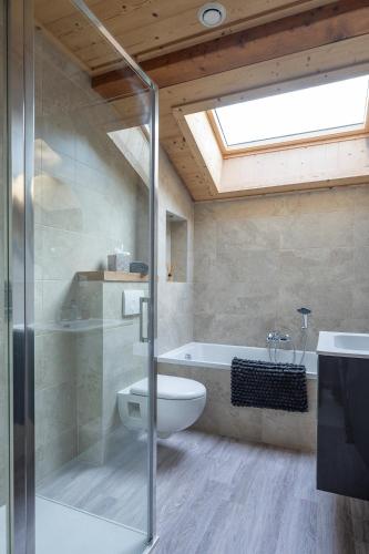 La salle de bains est pourvue d'une douche, de toilettes et d'une baignoire. dans l'établissement Chalet Les Cyclamens, aux Gets