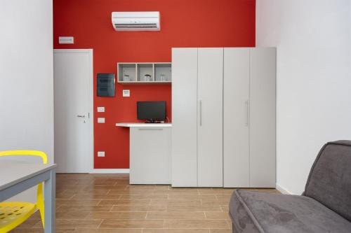a living room with white cabinets and a red wall at Vele Storiche Pisane in Pisa