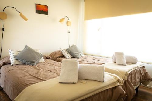 1 dormitorio con 2 camas y toallas. en Buenavista Chalten, Casa de Montaña en El Chaltén