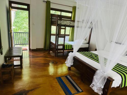 a bedroom with two beds with mosquito nets at River Splendour Home Stay in Ella