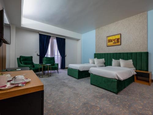 ein Hotelzimmer mit 2 Betten und einem Schreibtisch in der Unterkunft فندق بغداد Baghdad International Hotel in Bagdad