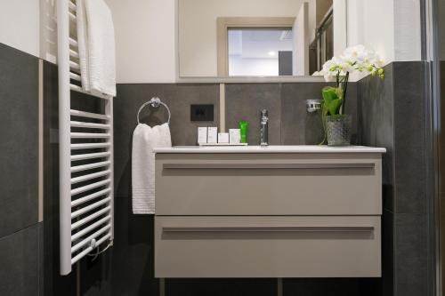 a bathroom with a white sink and a mirror at Emerald Green Residence in Caldiero