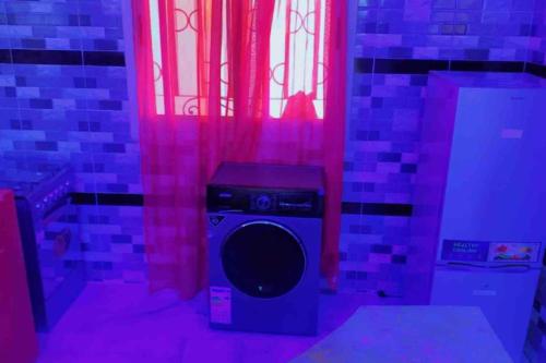 een kamer met een luidspreker in een kamer met roze verlichting bij Résidence Les Bernier in Nianing