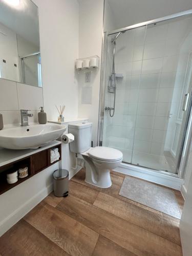 La salle de bains est pourvue de toilettes, d'un lavabo et d'une douche. dans l'établissement My Apartment Brixton - Modern Double Room with En-suite, à Londres
