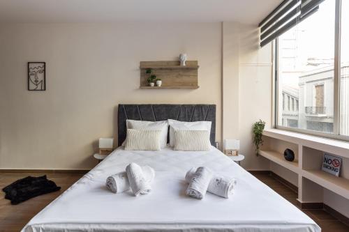 um quarto com uma grande cama branca com 4 almofadas em Aristotelous Plaza View Studio em Tessalônica