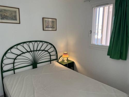 une chambre avec un lit blanc et une fenêtre dans l'établissement ARCHIPEL III Joli 2 Pièces avec clim réversible proche plage Richelieu Piscine Cap d'Agde, au Cap d'Agde