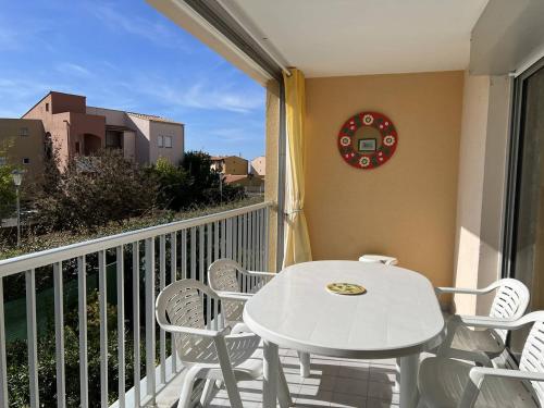 une table blanche et des chaises sur un balcon dans l'établissement ARCHIPEL III Joli 2 Pièces avec clim réversible proche plage Richelieu Piscine Cap d'Agde, au Cap d'Agde