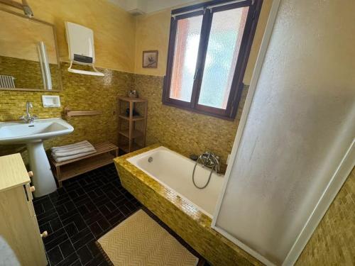 une salle de bain avec une baignoire et un lavabo dans l'établissement Appartement 6 couchages à Auron, à Auron