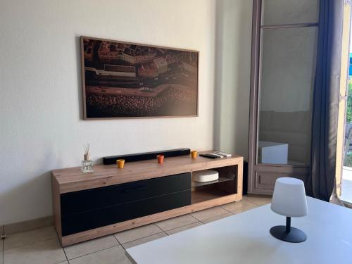 ein Wohnzimmer mit einem Tisch und einem Stuhl in der Unterkunft Appartement T2 avec jardin privé, piscine et barbecue in Lorgues
