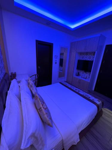 een slaapkamer met een wit bed en een blauw plafond bij Summer Beach Maldives in Male City