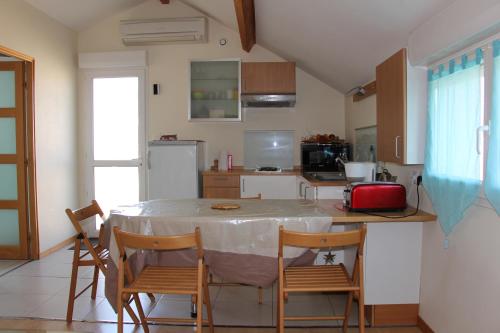 a kitchen with a table and chairs in a room at Meublé 2* climatisé dans un quartier calme in Dijon