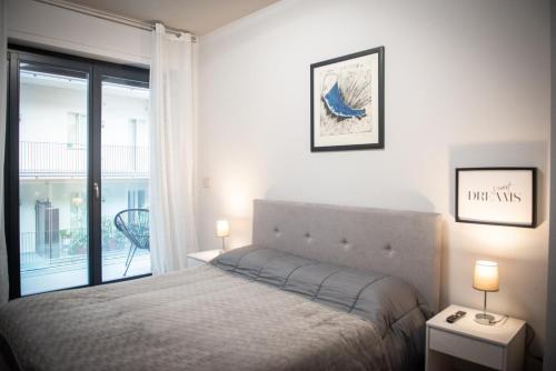 een slaapkamer met een bed en een raam met een balkon bij Elegante Bilocale-Centro Torino-Free WiFi in Turijn