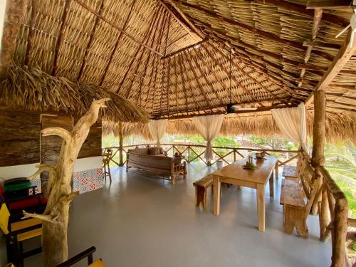 El Puertón的住宿－Cabaña CasaMar Angelica，一间设有桌子和稻草屋顶的客房