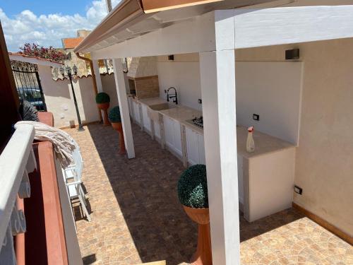 une cuisine extérieure avec des placards blancs et un comptoir dans l'établissement Villa Zaccaria - villetta indipendente, à Mazara del Vallo