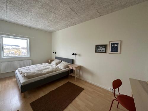 a bedroom with a bed and a window at Modern seaview house Ilulissat in Ilulissat