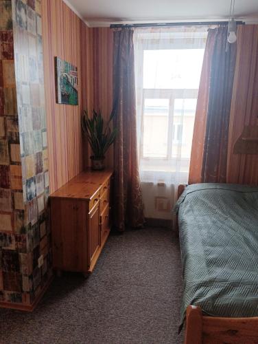 a bedroom with a bed and a dresser and a window at Ainas flat in Saldus