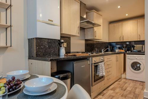 a kitchen with a table with bowls of fruit on it at Pass the Keys Modern Ground Floor Apartment in Shifnal