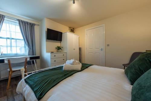 een slaapkamer met een groot bed en een televisie aan de muur bij Pass the Keys Modern Ground Floor Apartment in Shifnal