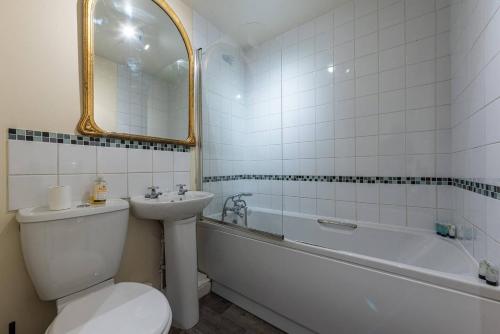 een badkamer met een toilet, een wastafel en een bad bij Pass the Keys Modern Ground Floor Apartment in Shifnal