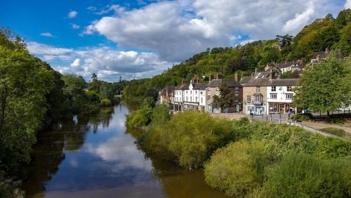 a river in a small town with houses and buildings at Pass the Keys Modern Ground Floor Apartment in Shifnal