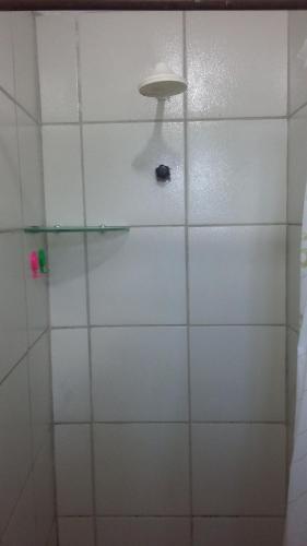 a shower with a white tile wall with a light at Apartamento e Suítes Mobiliada Climatizada Campo Grande in Recife