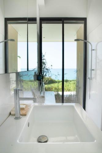 a white bath tub with a view of the ocean at Zita Fidar in Al Fīdār