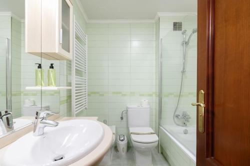y baño con lavabo, aseo y ducha. en Estudio moderno con parking by CABANA Rentals, en Vigo