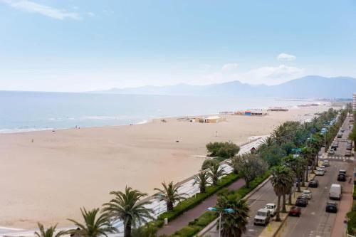 - une vue sur une plage avec des palmiers et des voitures dans l'établissement Bienvenu au Mar Estang, à Canet