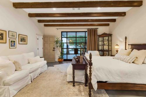een grote slaapkamer met een bed en een bank bij Luxury king suite downtown w lush garden terrace in Tucson