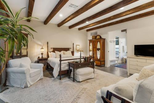 een grote kamer met 2 bedden en een televisie bij Luxury king suite downtown w lush garden terrace in Tucson