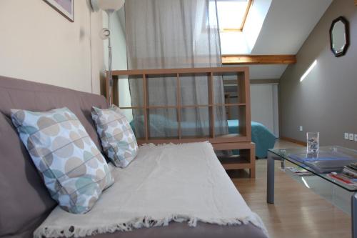 un salon avec un canapé et une table en verre dans l'établissement Meublé 2* climatisé dans un quartier calme, à Dijon