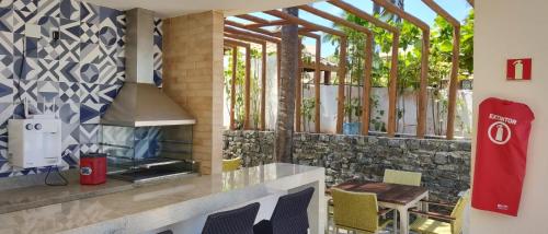 a outdoor kitchen with a stove and a fireplace at Itacimirim Apartments Boulevard e Ondas in Itacimirim