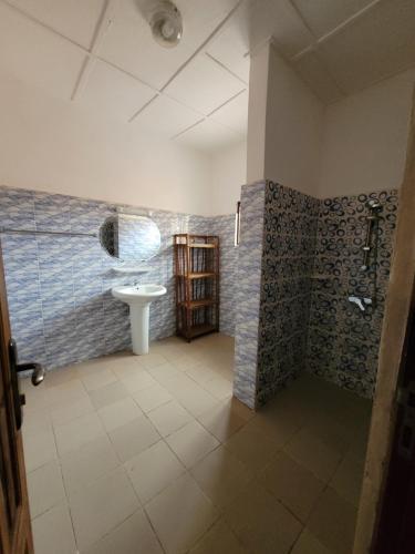 a bathroom with a sink and a toilet in a room at La Belle Vie Là de Ouidah in Ouidah