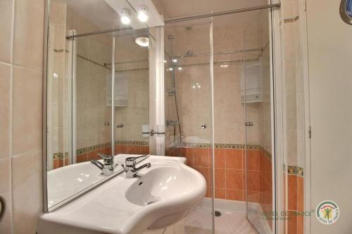 La salle de bains est pourvue d'un lavabo blanc et d'une douche. dans l'établissement Appart 2-3 personnes proche plage de la Fresnaye, à Saint-Cast-le-Guildo