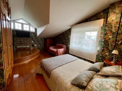 ein Schlafzimmer mit einem großen Bett und einem Fenster in der Unterkunft VILLA OSTRERA in Suances