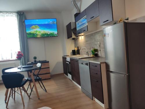 a kitchen with a stainless steel refrigerator and a table at Mini Apartament Studio in Głuchołazy