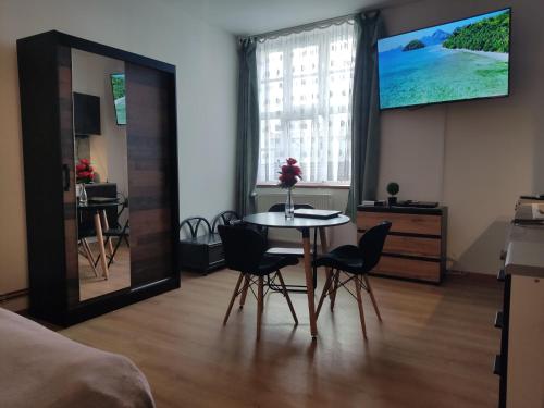 a room with a table and chairs and a television at Mini Apartament Studio in Głuchołazy
