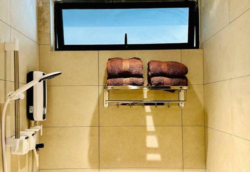 baño con toallero eléctrico y ventana en Beachfront Retreats @RoxyBeachSematanApt. en Sematan