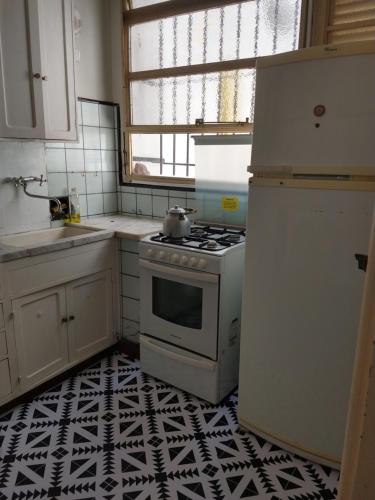 拉普拉塔的住宿－Casa chula，厨房铺有黑白地板,配有白色炉灶。